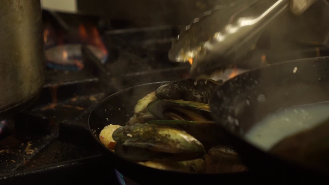 New Zealand Greenshell mussells, salmon, shrimps cooking in kitchen restaurant - CLOSE UP