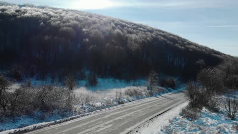 Drone-rise-over-car-road-in-sunny-winter-day