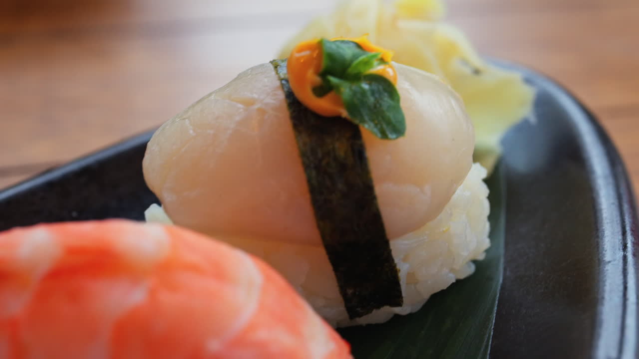 Close up of multiple nigiri on a black tray at a restaurant