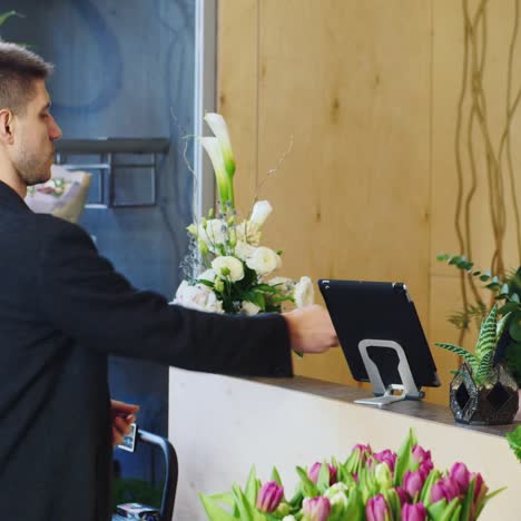 un joven empresario compra un ramo en una floristería 2