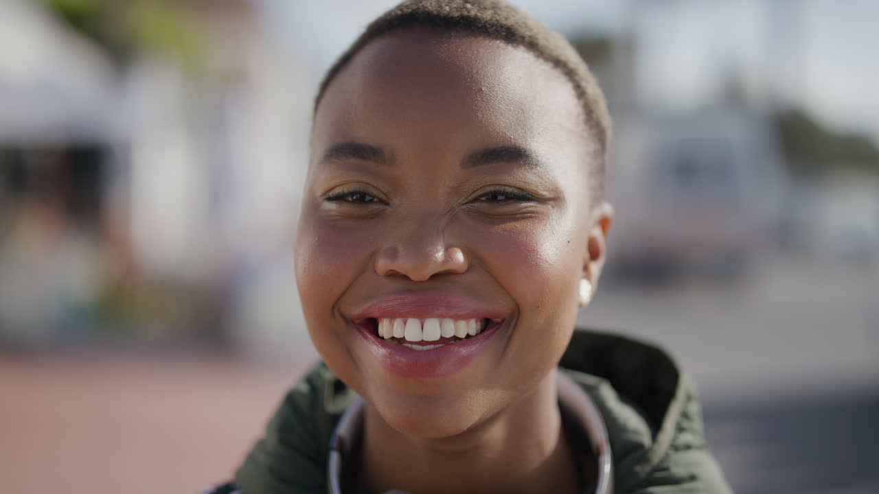 close up portrait of young beautiful african american woman smiling happy in vibrant urban beachfront enjoying summer
