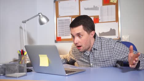 hombre mirando la computadora portátil en la oficina