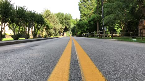 medio de una carretera de dos carriles en una pequeña ciudad desde una vista a nivel del suelo