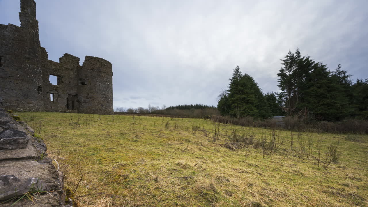 lapso de tiempo de la ruina de un castillo medieval en el campo rural de irlanda durante un día soleado y nublado