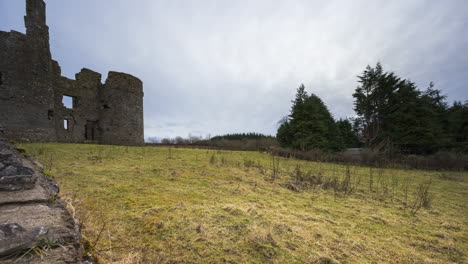 time lapse of a medieval castle ruin in rural countryside of ireland during a sunny cloudy day