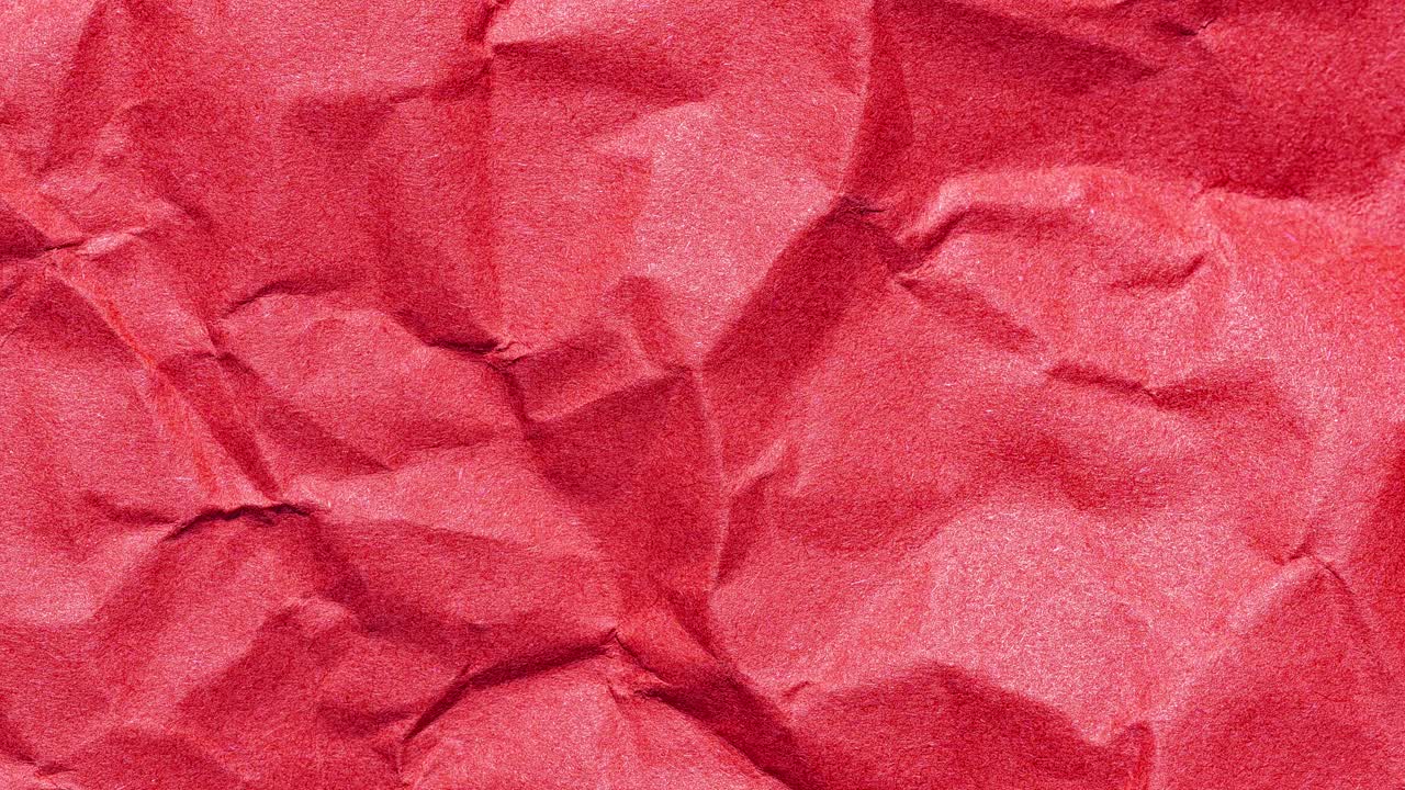 Seamless stop motion loop of wrinkled red paper shifting for an animated background with copy space