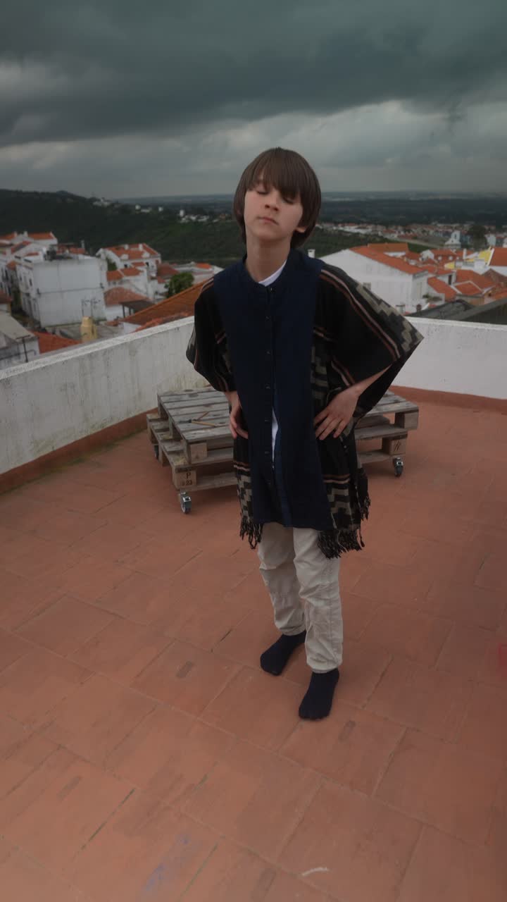 Ragazzo con un poncho su un tetto con vista sulla città