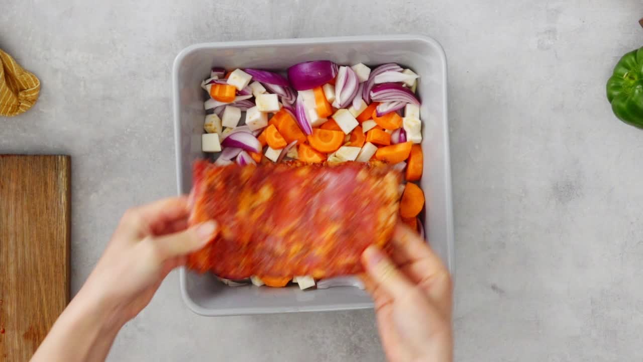 mujer de la cosecha poniendo costillas de cerdo en las verduras