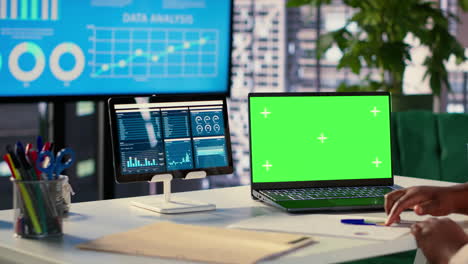 estación de trabajo de analista de negocios con portátil de pantalla verde