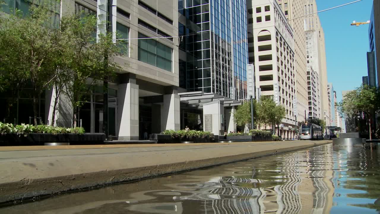 un tren de tránsito rápido se mueve rápidamente por el centro de houston con fuentes bailando 3
