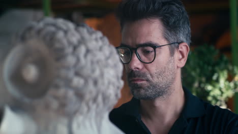 man observing an ancient sculpture