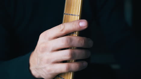 el guitarrista toma una vieja guitarra acústica de una caja negra grande.