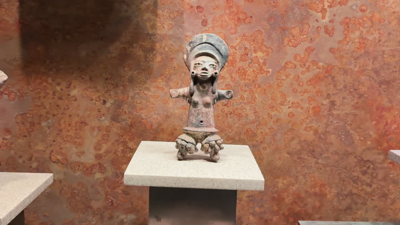 Pre-Columbian ceramic figurine on display at Museo Nacional de Antropología in Mexico City. Ancient Mesoamerican artifact showcasing indigenous craftsmanship and culture