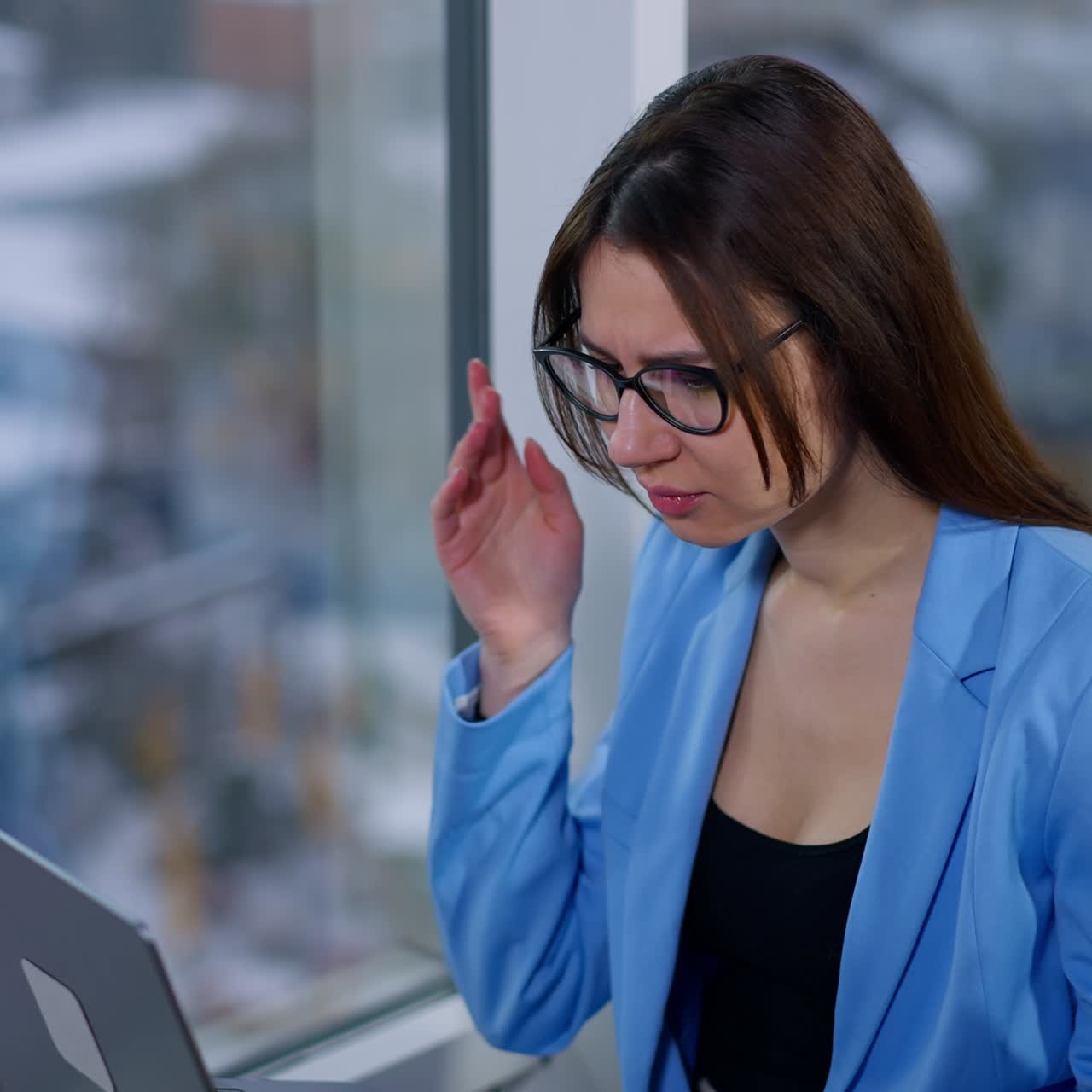 Freelancing woman working on laptop holding it on laps. Lady is puzzled with some problem occurred on computer