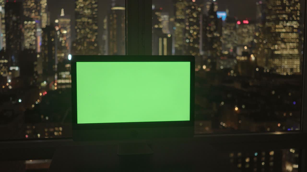 Computer with Greenscreen in Modern Office Building with Cityscape Background.