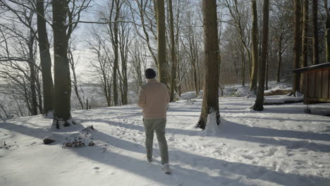 winter walk in sunshine, man enjoying a hot drink in a snowy forest