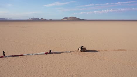 vista aérea de un grupo de hombres preparándose para lanzar un globo en el desierto