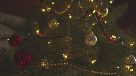 A-christmas-tree-decorated-with-red-and-white-baubles-at-night