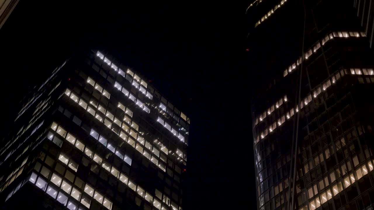 Nighttime cityscape with illuminated office buildings and skyscrapers in Frankfurt, Germany