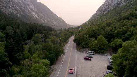 red convertible driving on beautiful mountain canyon road in utah - aerial