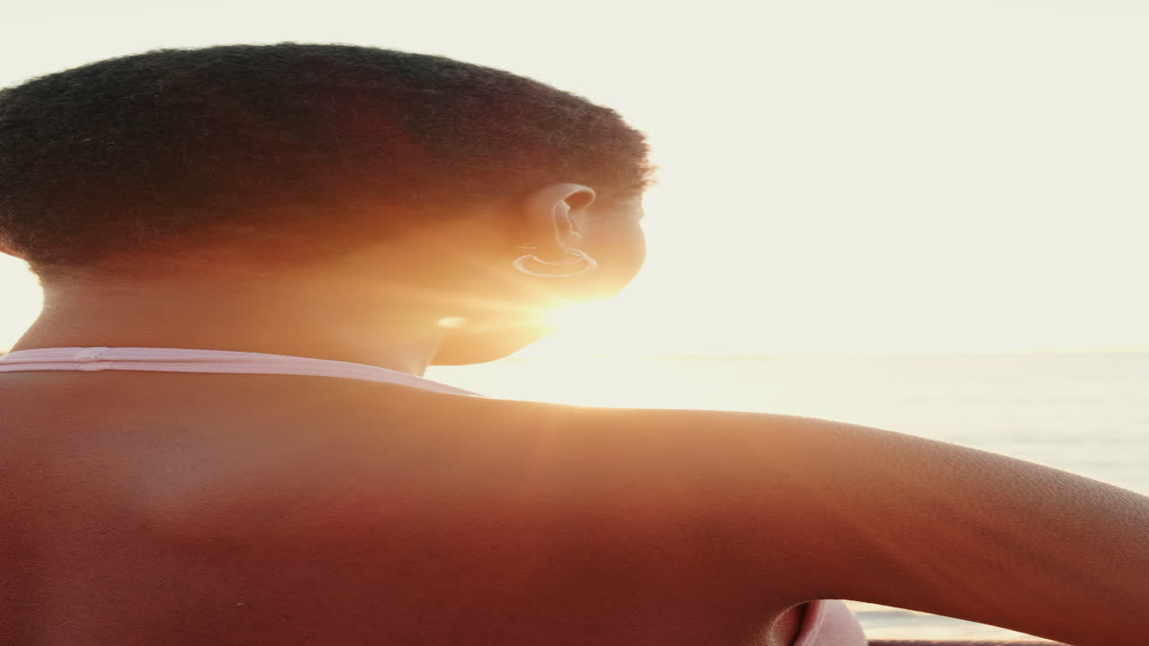 海辺で日の出を見ながら瞑想する女性