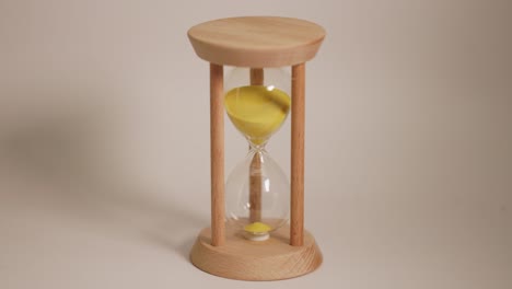 wooden hourglass with yellow sand