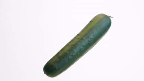 Large-green-whole-cucumbers-bouncing-on-white-backdrop-in-slow-motion