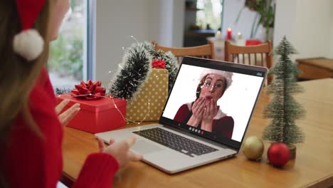 Kaukasische-Frau-Mit-Weihnachtsmütze,-Die-Zu-Weihnachten-Zu-Hause-Einen-Videoanruf-Auf-Dem-Laptop-Führt