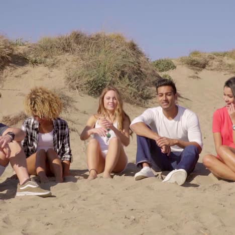 young people sitting on the beach