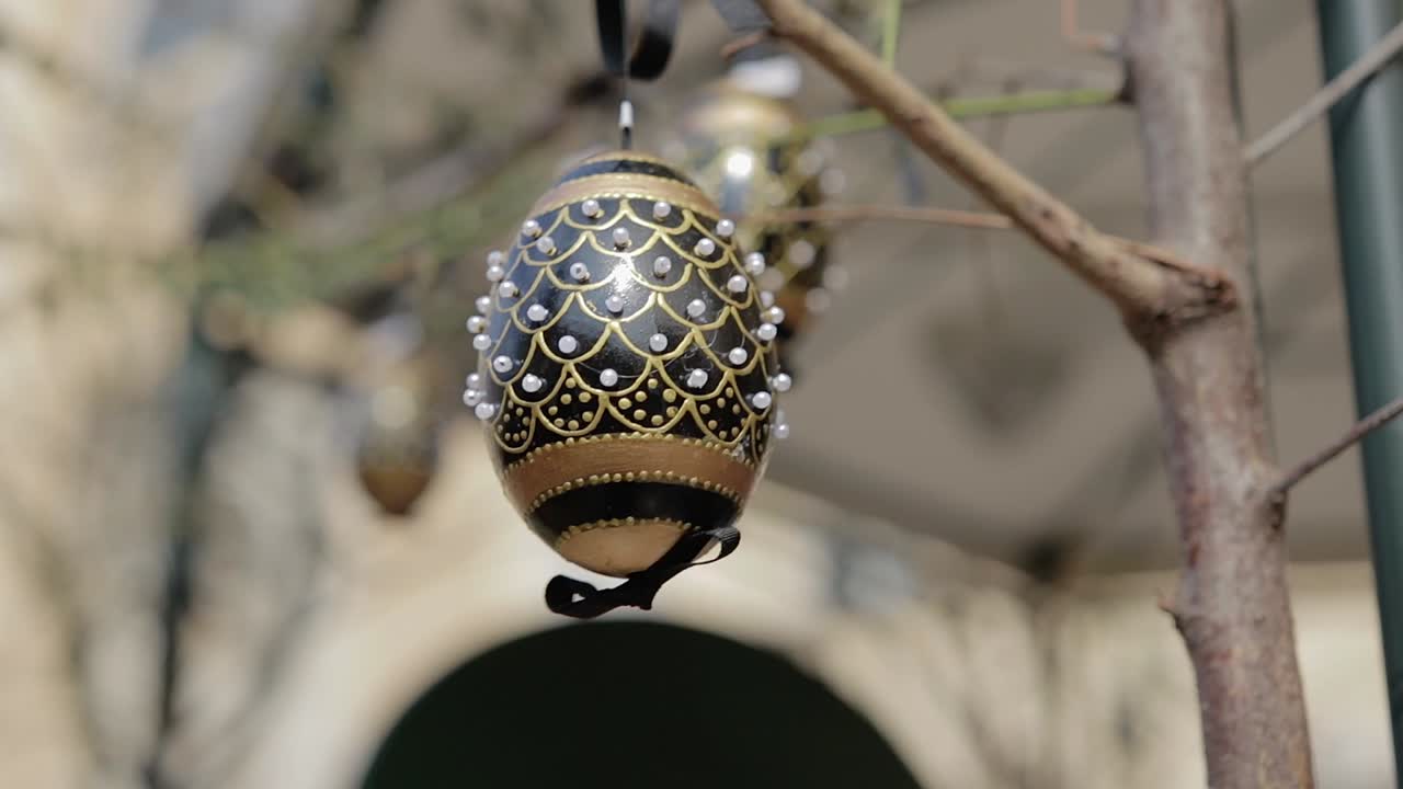Easter decorated eggs sway from the breeze. Focus shifts. Easter decorations. Slow motion