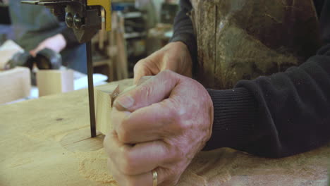 bespoke shoemaker shaping wooden last for shoe using jigsaw