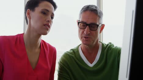 Front-view-of-Caucasian-Business-people-discussing-over-computer-at-desk-in-office-4k