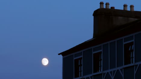 moon shinning beside an old house