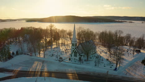 Gorgeous-aerial-drone-view-of-a-snow-covered-small-town-and-frozen-lake