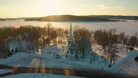 hermosa vista aérea de drones de una pequeña ciudad cubierta de nieve y un lago congelado