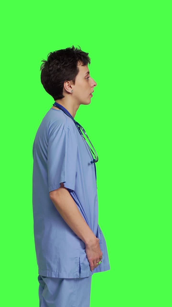 Profile Displeased nurse saying no and sighing against greenscreen backdrop