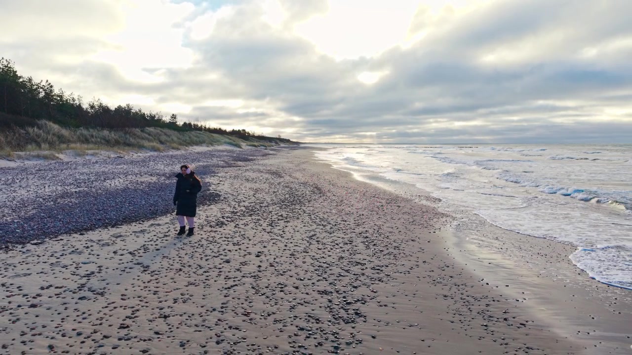 Woman Walking Toward Camera Along Nida Pebble Beach on Latvia Baltic Sea Coast