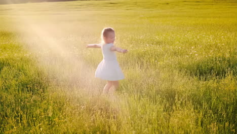 a girl in a white dress playing in a field