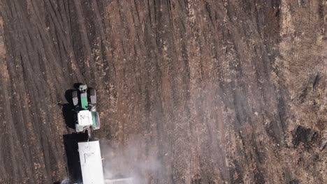 top view of a farm tractor adding lime to the natural soil in agricultural land