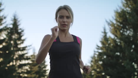 mujer joven entrenando como corredora en el parque de verano. mujer en forma correteando al aire libre