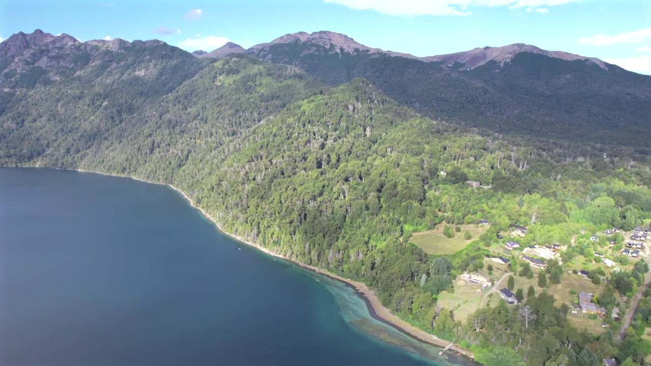 Ripresa aerea con drone in 4K del Lago Correntoso a Neuquén, Argentina. Acque cristalline circondate da fitte foreste patagoniche e le spettacolari vette delle Ande creano un paesaggio naturale mozzafiato