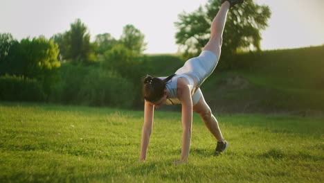 Woman-athlete-involved-in-fitness-in-park-doing-leg-lifts-on-mat.-Workout.-Work-on-a-beautiful-body-in-the-morning-or-at-sunset.-Exercises-for-leg-and-hip-muscles