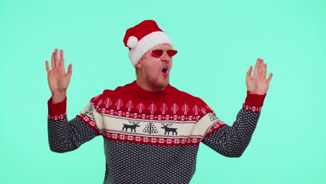 Man-in-Christmas-sweater-listening-music-via-earphones,-dancing-disco-fooling-around-having-fun