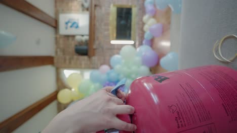 woman inflating a ballon from a tank of helium