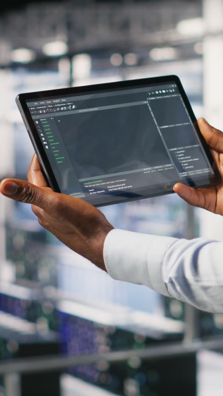 Vertical video Close up of data center programmer looking at code debugging tools on tablet