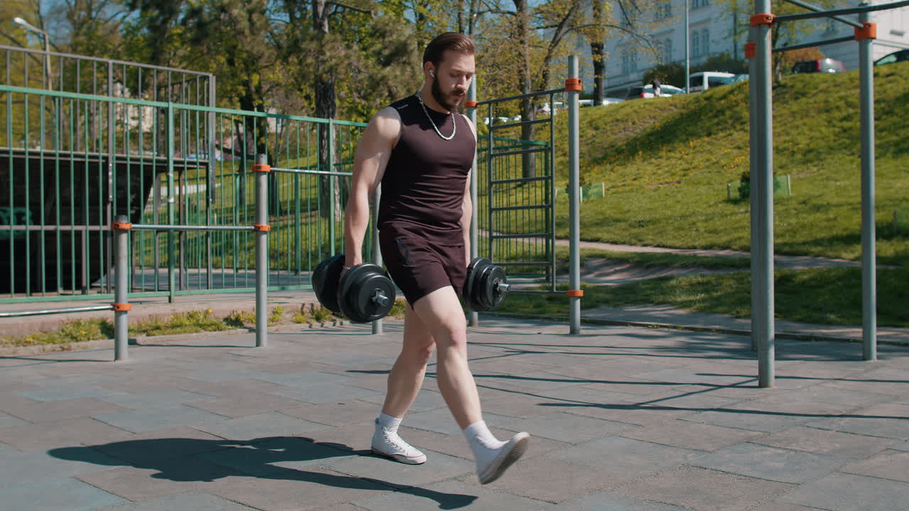 Uomo libanese atletico in abbigliamento sportivo che fa esercizi con i pesi, eseguendo squat con manubri in mano.