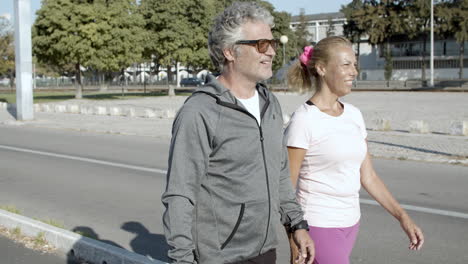 happy people in sportswear walking after training, talking