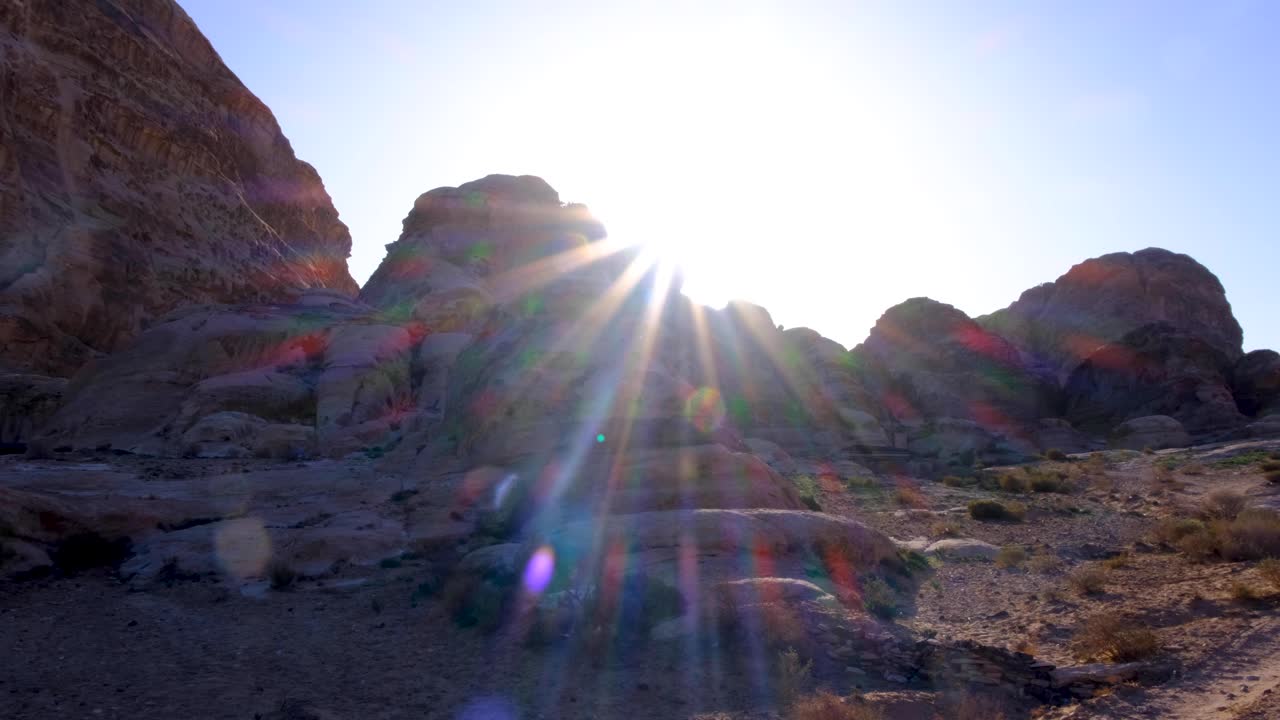 la luz del sol brillando sobre la cima del paisaje montañoso en la antigua ciudad de petra en jordania