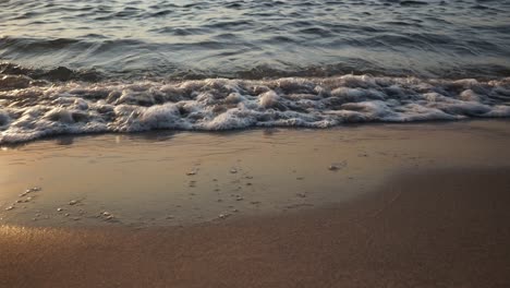 Olas-Rodando-En-La-Playa-De-Arena-Al-Atardecer,-Vista-Frontal