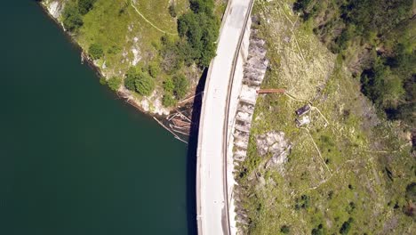 overhead aerial drone shot following a road on a seaside dam